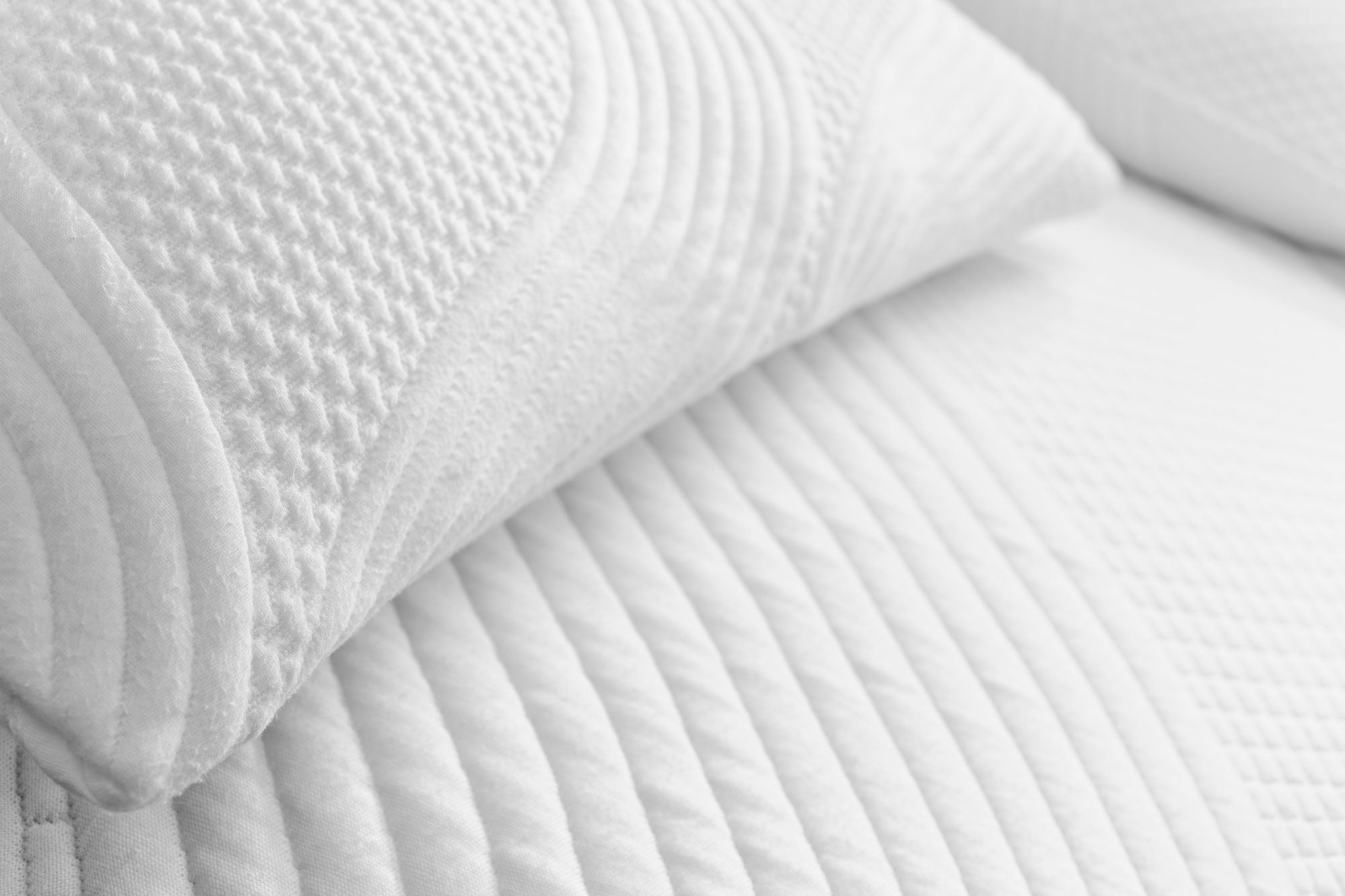 Close-up of Snuuzu Tesla camping mattress and pillow in organic Lyocell Tencel fabric showing premium quilted comfort detail