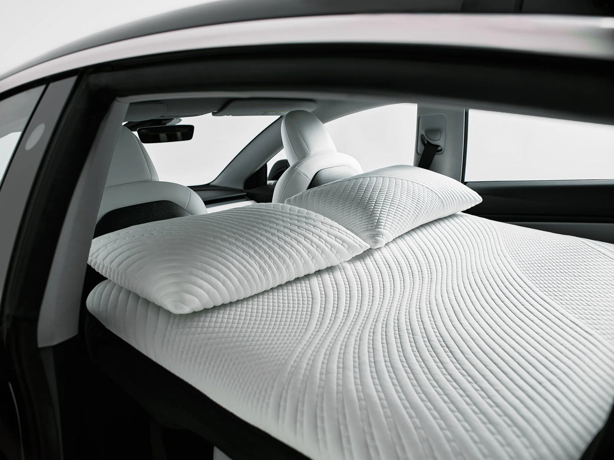 Side view of a Snuuzu Tesla Model 3 mattress inflated inside the car for camping and road trips.
