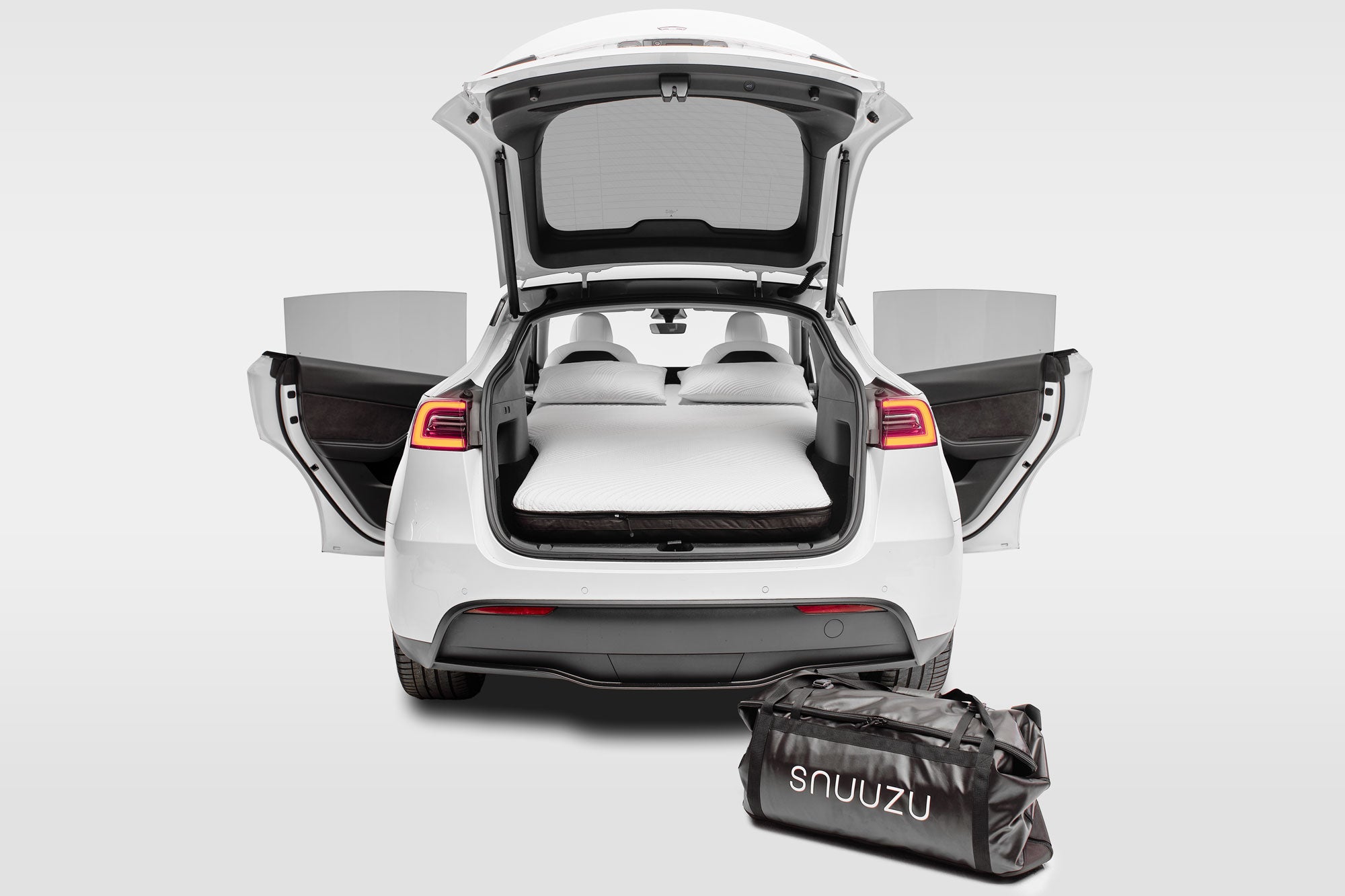Snuuzu Tesla Model Y car camping mattress fully installed with rear trunk open showing complete sleeping setup and integrated storage bag